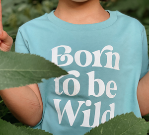 Camiseta born to be wild de Lorem Ipsum Brand. Camiseta para niños y niñas, de manga corta en color azul grasáceo con mensaje bron to be wild en blanco en la parte delantera. 100% algodón orgánico. 100% sostenible. Impresión digital de alta calidad. 